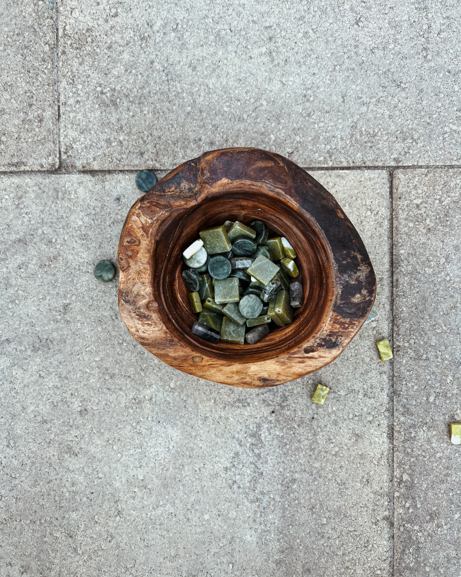 Photo of an overhead view of a wooden bowl full of serpentine crystals.